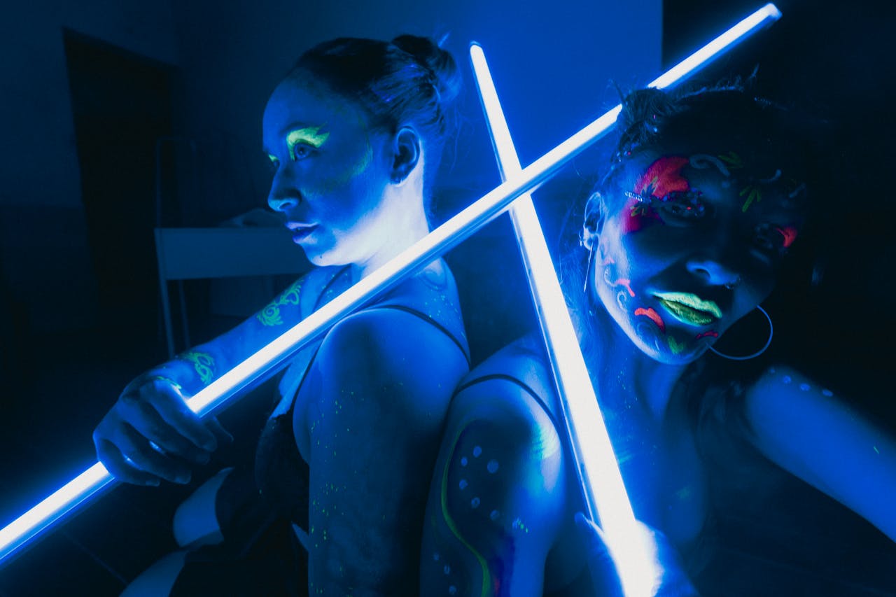 approach-img Women illuminated by neon colors and UV light create a vibrant, artistic scene in Mexico City.